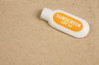 Sunscreen on Sand Background
